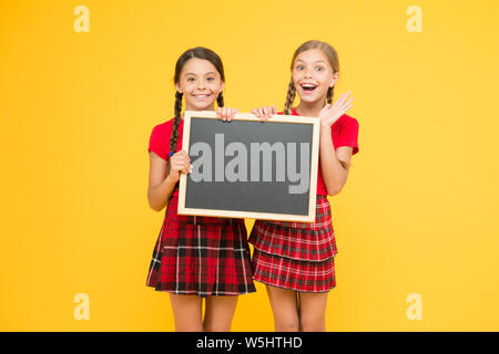 Équipe de l'initiative de camarades. Inscrivez-vous le club scolaire. Les élèves de la communauté. Cours de Cheerleading. L'annexe de l'école. School girls cute pupils uniforme rouge tenir copie tableau noir l'espace. Annonce école concept. Banque D'Images