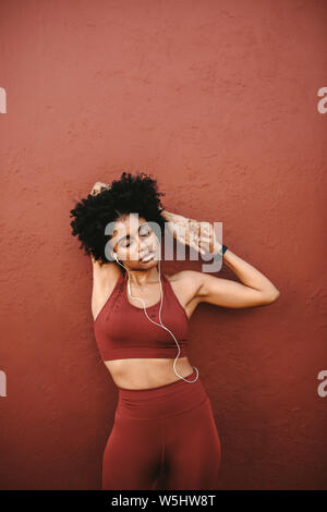 African American Woman in fitness porter un moment d'entraînement. Athletic woman relaxing ses muscles du bras après l'exercice. Banque D'Images