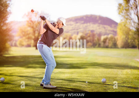 Old man swinging golf club. Banque D'Images