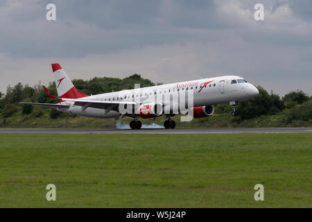 L'Austrian Airlines Embraer ERJ-195LR atterrit à l'Aéroport International de Manchester (usage éditorial uniquement) Banque D'Images