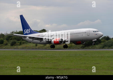 Un SAS Scandinavian Airlines Boeing 737-800 atterrit à l'Aéroport International de Manchester (usage éditorial uniquement) Banque D'Images