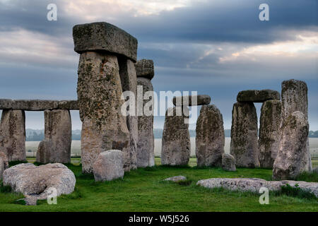 Pierres incrustés de lichen avec linteaux à Stonehenge le cercle de pierre préhistorique ruines dans la plaine de Salisbury les champs cultivés dans le Wiltshire en Angleterre à l'aube Banque D'Images