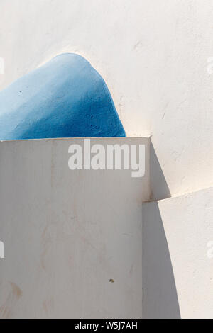 Résumé d'angles et de courbes de murs blancs et de dômes bleus de bâtiments à Megalochori, Santorini, Grèce Banque D'Images