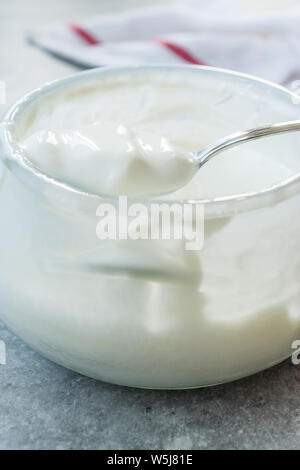 Yaourt de chèvre faits maison dans un bol en verre avec cuillère / crème probiotiques. Produit biologique. Banque D'Images
