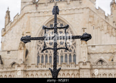 Une croix noire avec l'avant de la cathédrale d'Exeter, une cathédrale historique datant de 1270. Un lieu de culte anglican. Banque D'Images