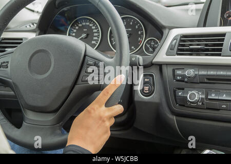 La fille avec la manucure ne cesse de mains sur le volant de la voiture Banque D'Images