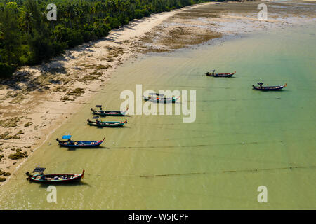 Vue aérienne de Longtail traditionnels en bois bateaux amarrés au large de la plage de sable tropicale, calme Banque D'Images