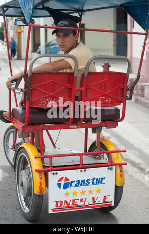 Jeune Cubaine location avec chauffeur de taxi se détend sur son vélo Banque D'Images