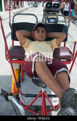 Jeune Cubaine location avec chauffeur de taxi se détend sur son vélo Banque D'Images