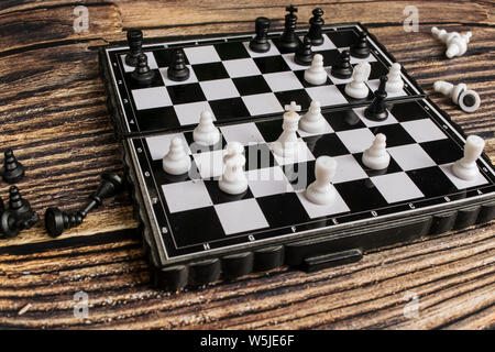 Petite poche échecs sur une table en bois. Banque D'Images