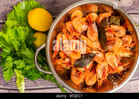 Les crevettes de l'Atlantique cuit autour de l'écoulement dans une passoire en acier inoxydable. Banque D'Images