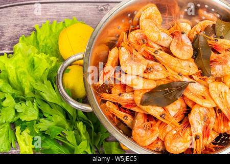 Les crevettes de l'Atlantique cuit autour de l'écoulement dans une passoire en acier inoxydable. Banque D'Images