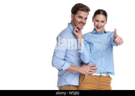 Embrassé happy casual couple, femme fait le signe ok sur fond blanc Banque D'Images