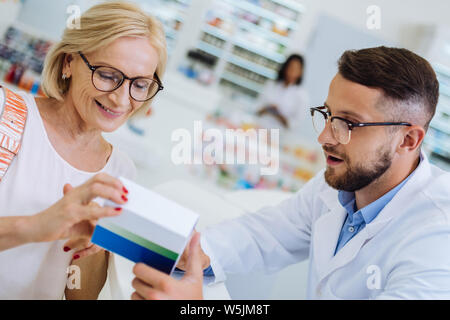 Mignon femelle mature personne lisant composition du médicament Banque D'Images