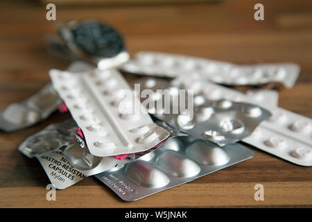 Photographie de table de plusieurs bandes de médicaments avec une montre en arrière-plan pour indiquer le temps de la dose. Banque D'Images