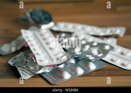 Photographie de table de plusieurs bandes de médicaments avec une montre en arrière-plan pour indiquer le temps de la dose. Banque D'Images