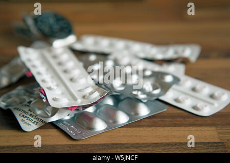 Photographie de table de plusieurs bandes de médicaments avec une montre en arrière-plan pour indiquer le temps de la dose. Banque D'Images