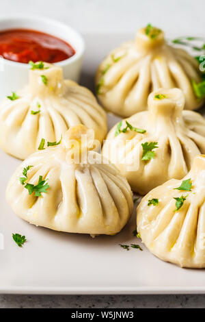 Khinkali boulettes traditionnelle géorgienne avec farce à base de viande et les verts sur un plat blanc. Banque D'Images