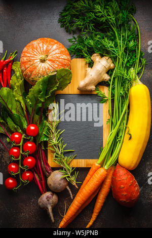 Les légumes d'automne arrière-plan. Potiron, courgette, patates douces, carottes et betteraves sur un fond sombre. Banque D'Images