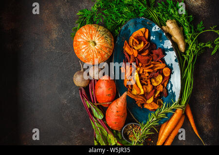 Plat de légumes sains jetons de betteraves, carottes et patates douces avec des ingrédients sur fond sombre, vue du dessus. Banque D'Images