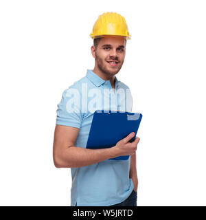 Portrait de l'ingénieur détendue polo bleu portant des poches et en en étant debout sur fond blanc Banque D'Images