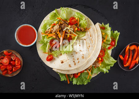 Burritos wraps au poulet et légumes sur ardoise noire. Burrito poulet, la nourriture mexicaine Banque D'Images