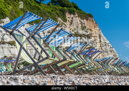 La bière, au sud de l'est du Devon, Angleterre. Lundi 29 juillet 2019. Météo britannique. Avec un ciel bleu et une douce brise, la plage de la pittoresque village de bord de la bière voit moins de touristes assis dans les chaises longues en pleine tempête devrait frapper la côte sud du Devon plus tard aujourd'hui. Credit : Terry Mathews/Alamy Live News Banque D'Images