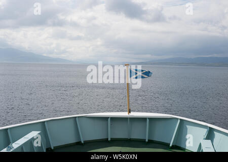 Drapeau écossais sur la proue d'un ferry Caledonian Macbrayne quittant le port à Oban, Ecosse, voyageant vers l'île d'Islay. Banque D'Images