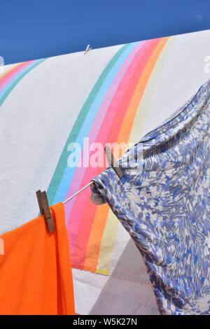 Feuille et tee shirts en train de sécher dehors, dans le vent. Ligne de lavage sur l'ensoleillé et très venteux jour. L'accent sur un seul sélective vêtements en bois peg. Banque D'Images