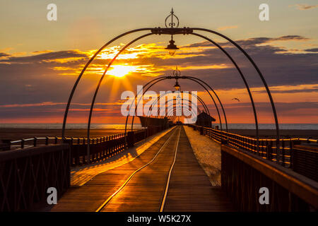 Southport, Merseyside, Royaume-Uni. 29 juillet 2019. Un beau coucher de soleil se niche dans le lit derrière la jetée de Southport Merseyside. Ouvert en août 1860, c'est la plus ancienne jetée de fer dans le pays. Sa longueur de 1 108 m en fait le deuxième plus longue en Grande-Bretagne. Credit : Cernan Elias/Alamy Live News Banque D'Images