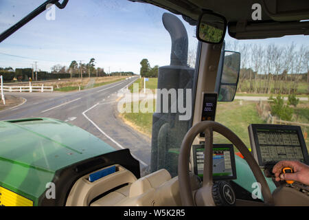 Sheffield, Canterbury, Nouvelle-Zélande, le 27 juillet 2019 : Un agriculteur conduit un grand tracteur John Deere d'un champ agricole sur les routes de campagne Banque D'Images