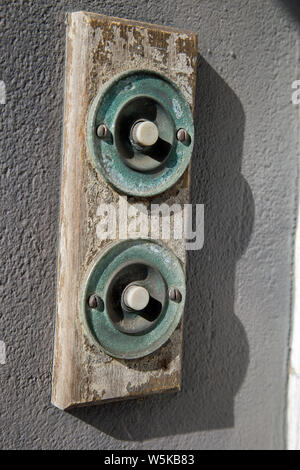 Deux boutons de sonnette de la porte d'époque sur une planche en bois disposées verticalement et shot close up Banque D'Images