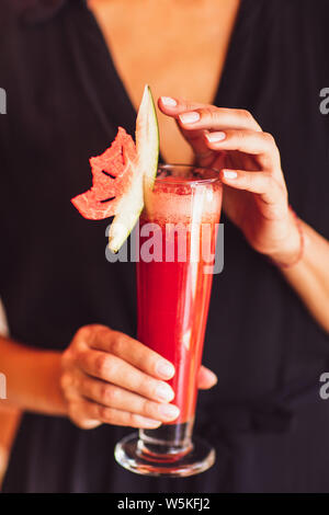 Verre de délicieux jus de melon d'eau saine chez les jeunes femmes. Boisson saine concept. Banque D'Images