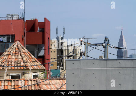 La tour du bâtiment NTT DoCoMo Yoyogi (à droite) vu au-dessus des toits de Tokyo, près de Shinjuku, Japon. Banque D'Images