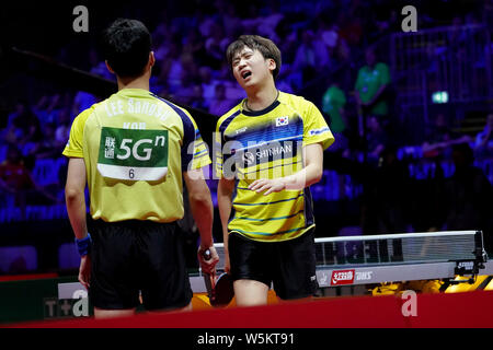 Jeoung Young-Sik et Lee Sang-su de Corée du Sud réagissent comme ils font concurrence à l'encontre de ma longue et Wang Chuqin de Chine en match quart de leurs hommes. Banque D'Images