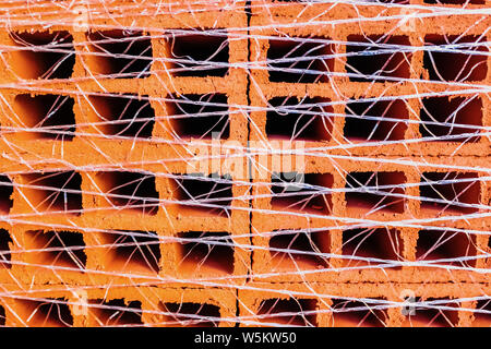 Une palette avec des centaines de briques à utiliser dans la construction d'une maison. Banque D'Images