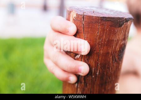 Close-up of a baby's hand saisissant un tronc pour soutenir son apprentissage de la marche. Banque D'Images