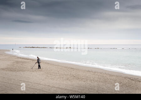 Photo de paysage de l'homme la numérisation de la plage avec un détecteur de métal Banque D'Images