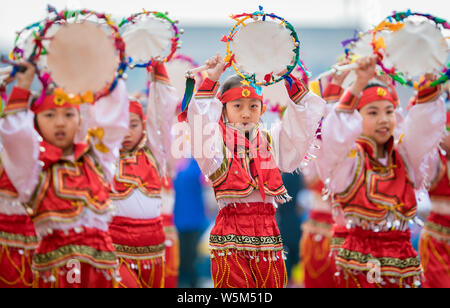Les élèves des écoles primaires habillés en costumes traditionnels prennent part à une séance de sport à l'école primaire de la ville de Hohhot, en Mongolie intérieure de la Chine du nord Banque D'Images