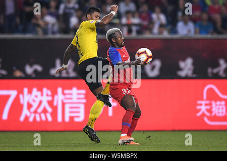 Joueur de football brésilien Paulinho, gauche, de Guangzhou Evergrande Taobao passe le ballon contre le joueur de football brésilien Fernandinho Henrique de Cho Banque D'Images