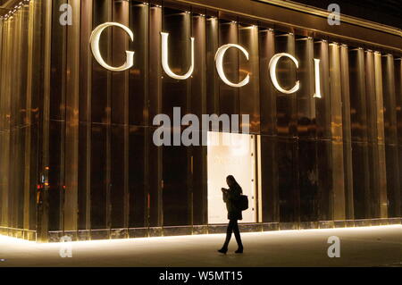 --FILE--un piéton chinois passe devant un magasin de Gucci à Beijing, Chine, 23 novembre 2013. Groupe de luxe français Kering S.A., propriétaire de Gucci, Yve Banque D'Images