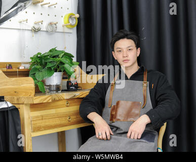 Garçon chinois de l'ethnie Tujia Cailin Liu, une académie des beaux-arts de Hebei diplômé, pose à son atelier dans le centre de la Chine, la province du Hubei, le 6 avril Banque D'Images