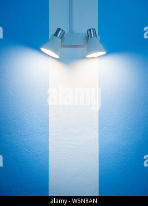 Lampe Murale rayés bleus et blancs sur fond de mur avec copie espace style vertical. Banque D'Images