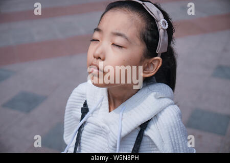 13-year-old fille chinois Zhang Bohan diagnostiqué avec la maladie de Gaucher, montre son ventre sur une route dans la province de l'Anhui en Chine orientale, le 29 mars 2019 Banque D'Images