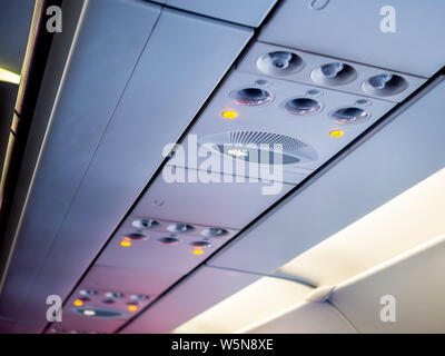 Les frais généraux et les icônes du panneau de commande en classe économique en avion pour régler la climatisation et d'éclairage, vue depuis le siège du passager. Banque D'Images