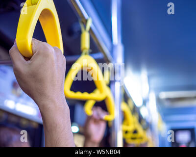 Close-up hand holding poignée jaune dans le bus-navette dans l'aéroport. Banque D'Images