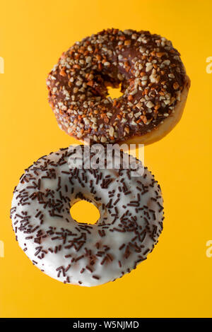 Flying donuts sucré sur un fond jaune Banque D'Images