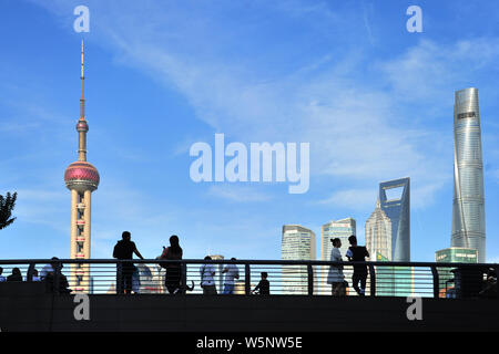 Les touristes visitent la promenade sur le Bund, le long de la rivière Huangpu pour afficher l'Oriental Pearl TV Tower, plus haut à gauche, la Tour de Shanghai, plus haut à droite, Banque D'Images