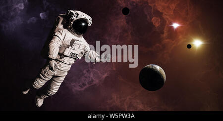 Astronaute en nébuleuse colorée avec les planètes et lunes Banque D'Images