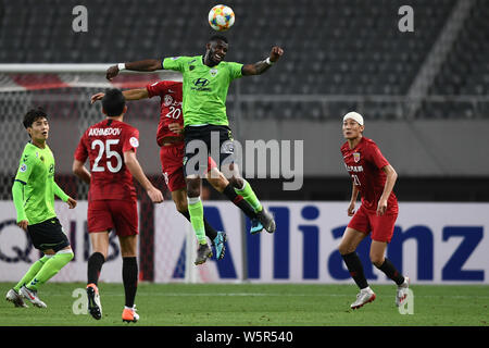 Joueur de football australien Bernie Ibini-Isei, également connu simplement comme Bernie Ibini, haut, de Corée du Sud de Jeonbuk Hyundai Motors FC chefs la balle contre Banque D'Images